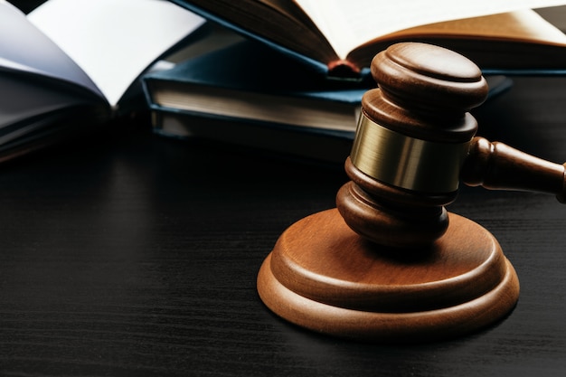 Judge's gavel on wooden table in dark