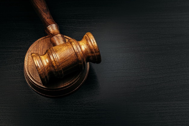 Judge's gavel on wooden table in dark