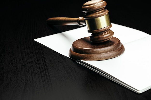 Judge's gavel on wooden table in dark