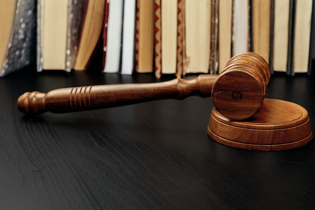 Judge's gavel on wooden table in dark