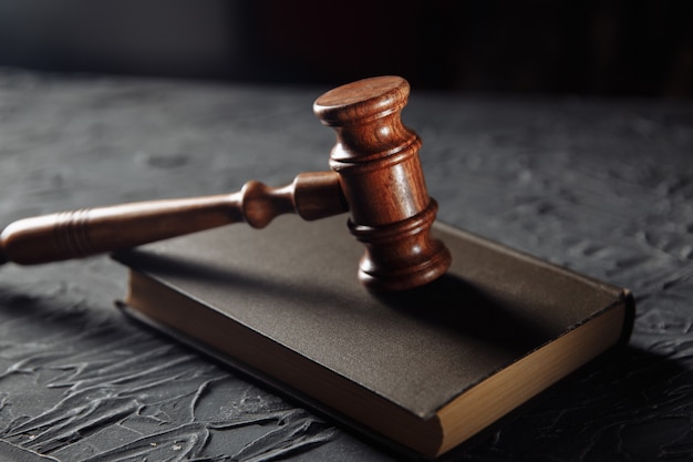 Judge's hammer and legal book on a table