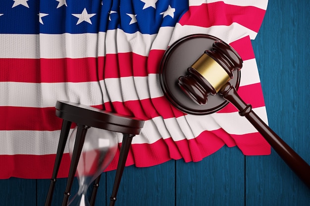 Photo the judge's hammerthe us flag and an hourglass lie on a blue wooden table