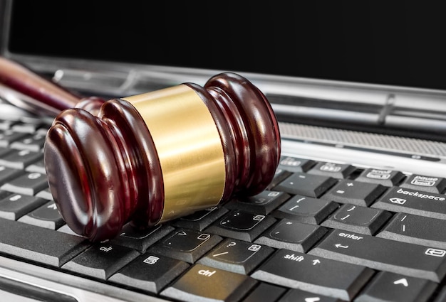 Judge's wooden gavel on laptop keyboard Close up Online auction and law concept