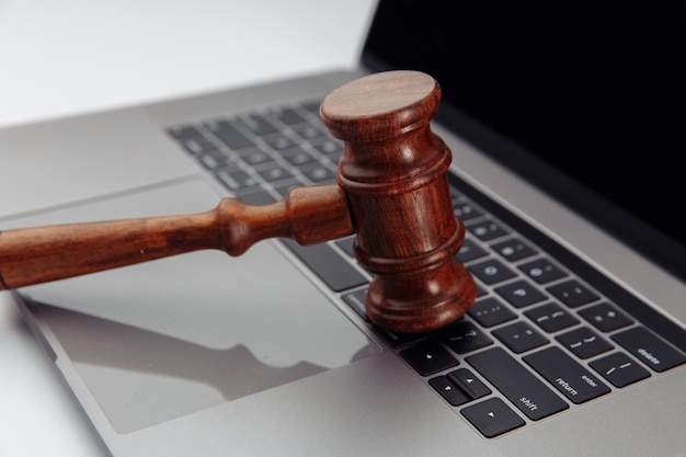 Judge's wooden gavel on laptop's keyboard