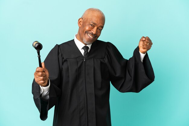 Judge senior man isolated on blue background doing strong gesture