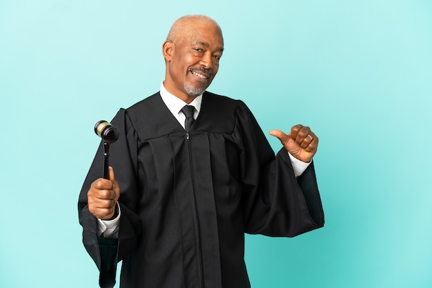 Judge senior man isolated on blue surface proud and self-satisfied