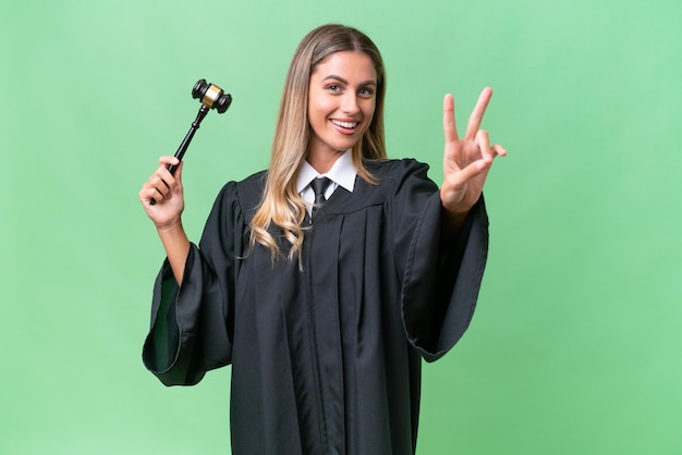 Judge Uruguayan woman over isolated background smiling and showing victory sign