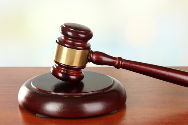 Judges gavel on wooden table on light background