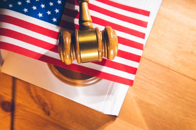 Judges wooden gavel with USA flag on the wooden background.