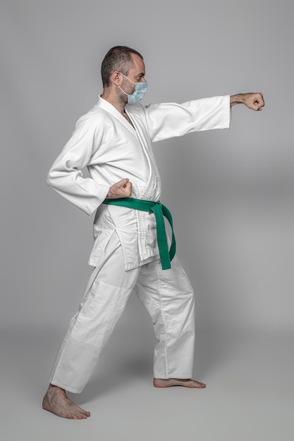 Il praticante di judo indossa una maschera protettiva durante l'allenamento. lo sport all'epoca del coronavirus