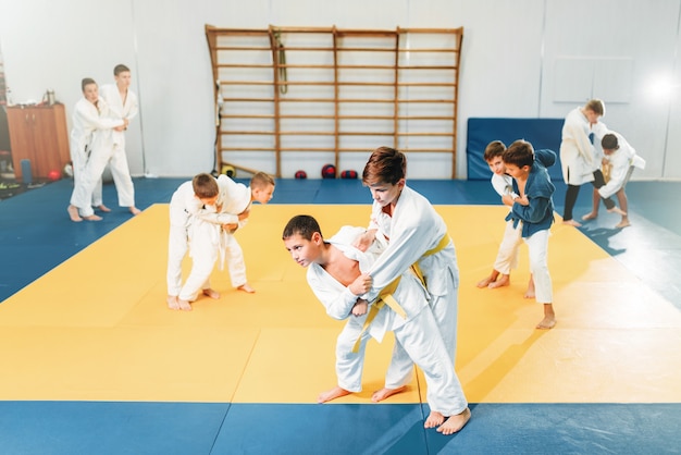 Judo voor kinderen, krijgskunst voor kinderen, zelfverdediging. Kleine jongens in uniform in sport sportschool, jonge vechters