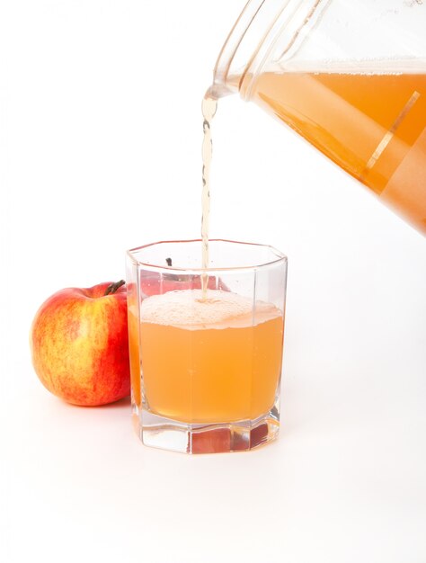 Jug of freshly squeezed apple juice, glass and two apples