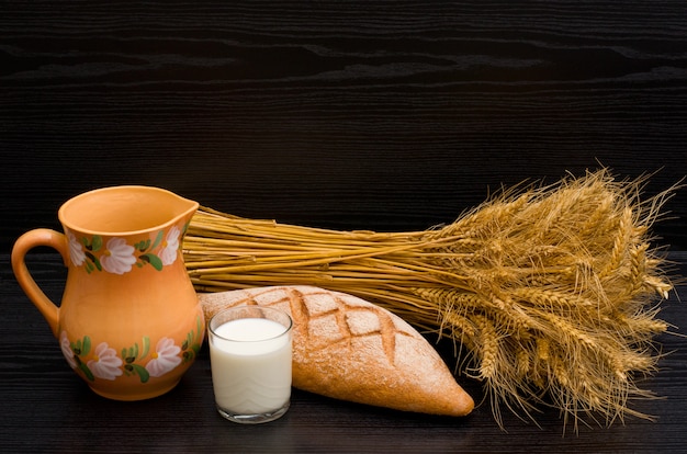 Jug, glass of milk, a loaf of rye and a sheaf