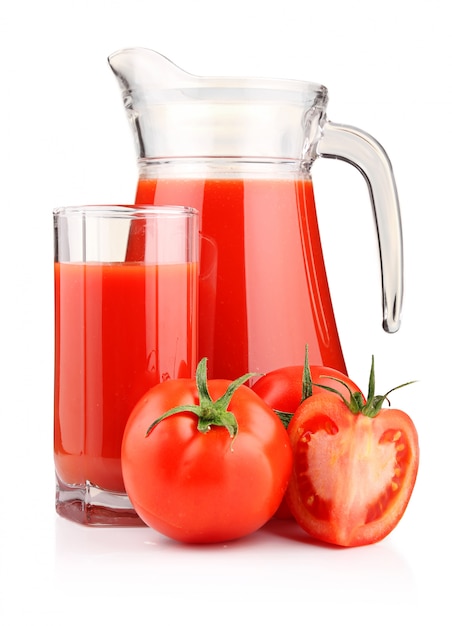 Jug, glass of tomato juice and fruits with green leaves isolated