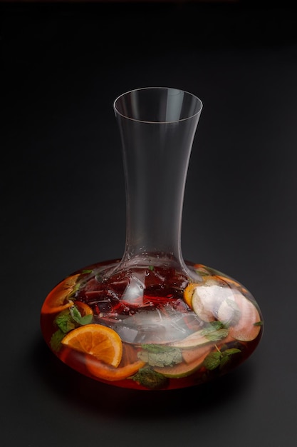 Jug of iced sangria isolated on black background