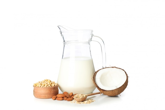 Jug of milk, soybeans, almond, oatmeal and coconut isolated on white