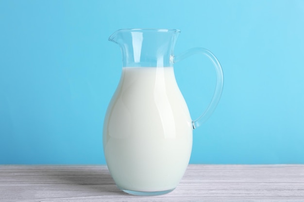 Jug of milk on white wooden table closeup