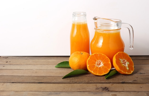 Jug of orange juice on wooden table