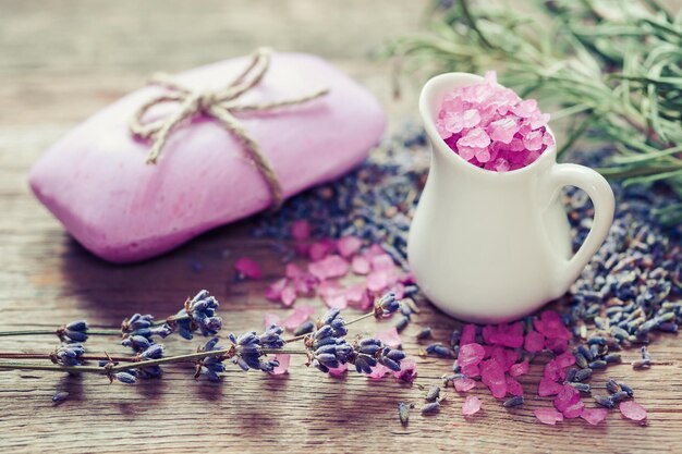 Jug of sea salt bar of homemade soap and dry lavender flowers