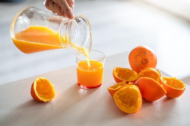 Foto una brocca e dei bicchieri di succo d'arancia appena spremuto a colazione per una vita sana