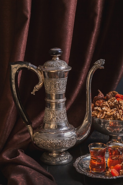 jug for water or tea, vase with dried fruit and plate with tea in armuda glasses