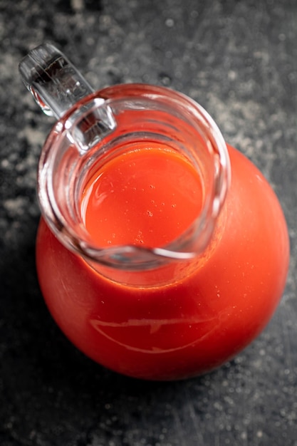 Jug with tomato juice on the table