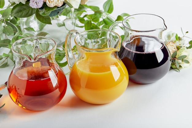 Jugs with different juices on event catering Apple orange, cherry and tomato juices