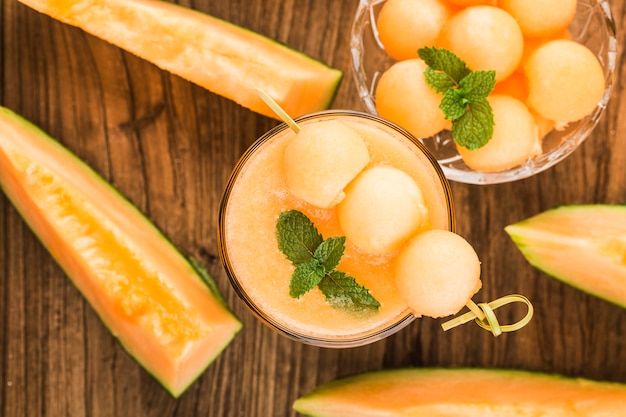Photo the juice of melon with mint in a glass on the table.hami melon