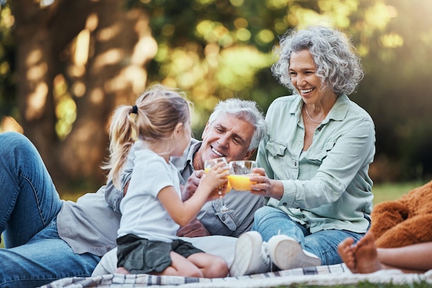 Photo juice vitamin c and family picnic with child and grandparents for healthy growth development outdoor wellness lifestyle senior grandmother elderly people and girl with orange drink in bokeh park