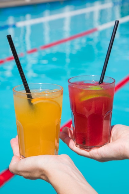 Juice and women hand with Female hands holding bottle Toasting with fruit smoothies