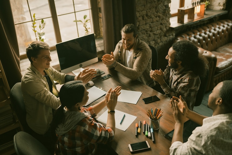 Foto juichende diverse freelancers team op vergadering