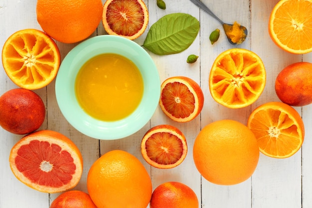 Juicing delicious oranges on white wooden table