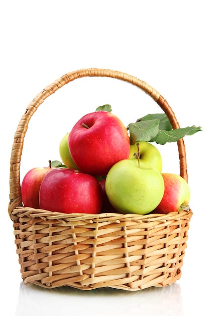 Juicy apples with green leaves in basket isolated on white