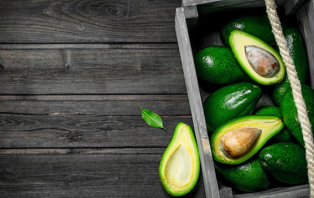 Juicy avocado and pieces of avocado in a wooden box