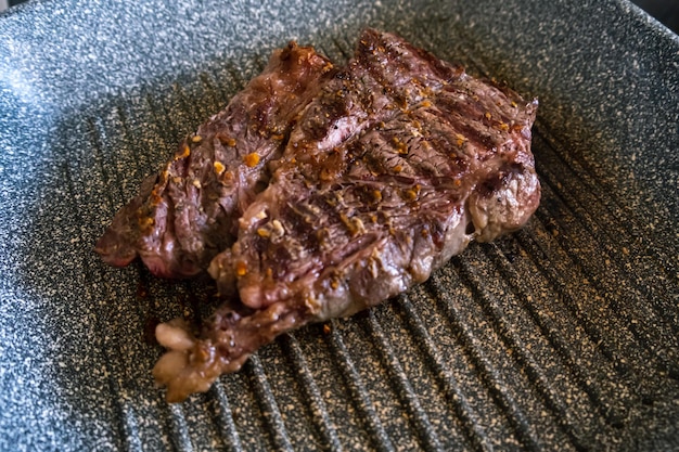 Juicy beef meat steak cooking on griddle pan at professional kitchen prime steak frying at grill del