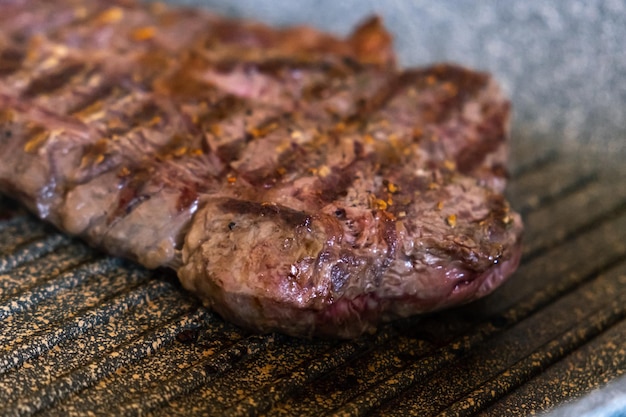 그릴 델에서 튀기는 전문 주방 프라임 스테이크의 철판 팬에서 요리하는 육즙 쇠고기 고기 스테이크