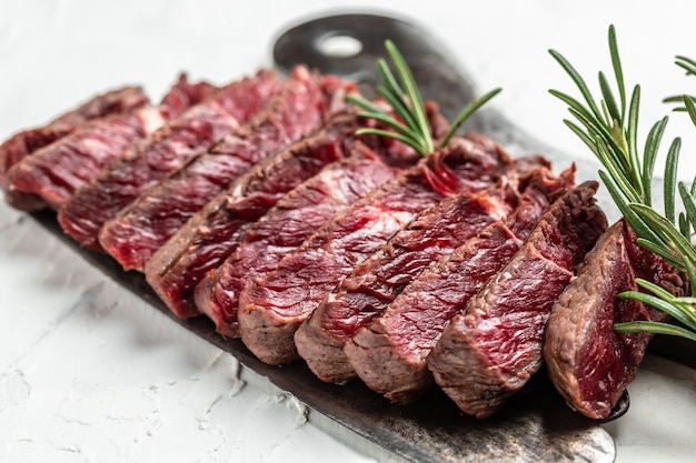 Juicy Beef rump steak from marble beef medium rare served on old meat butcher on light background, top view.