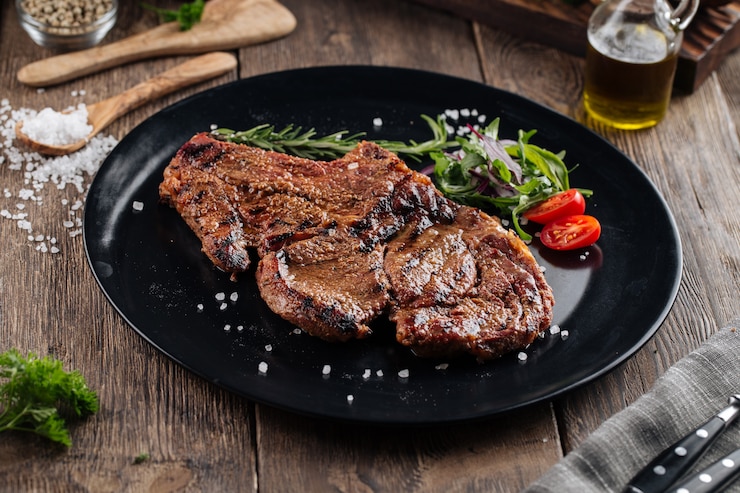 Photo juicy beef steak on a black plate