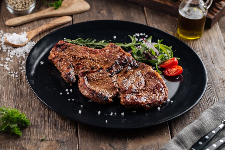 Photo juicy beef steak on a black plate