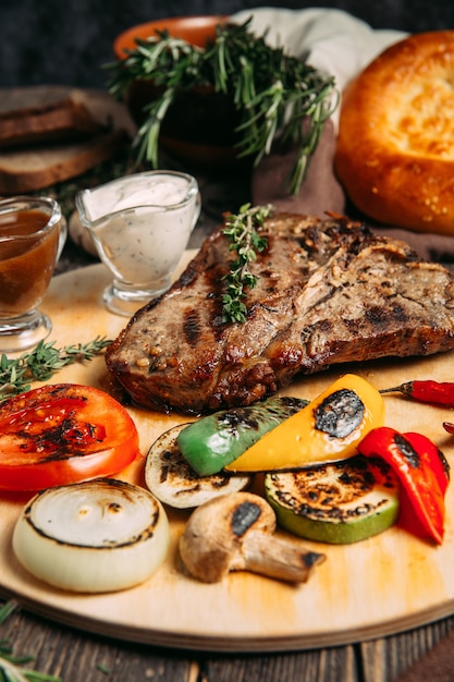 Juicy beef steak with grilled vegetables on board