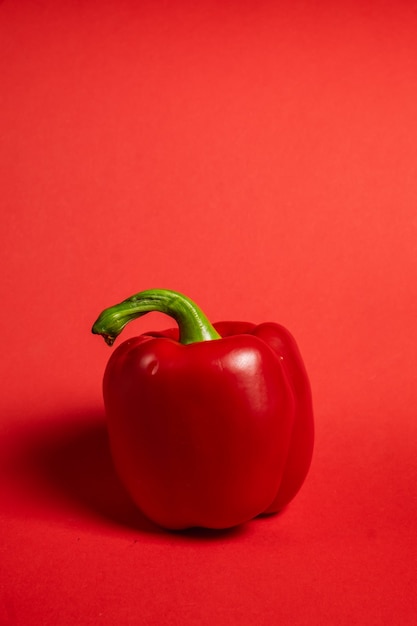 Juicy bell peppers on a bright red surface