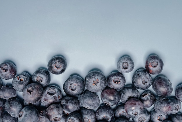 Juicy blueberries on a blue background Blueberry background Healthy berry organic food