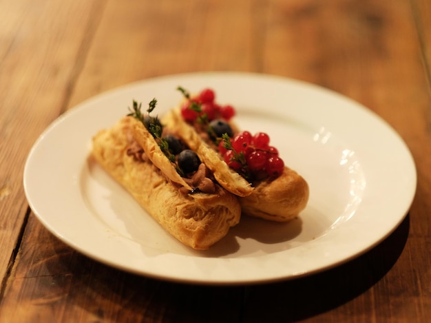 Juicy and bright eclairs with the taste of berries caramel and strawberries