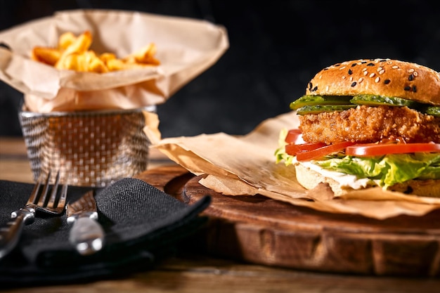 Juicy burger on the board black background dark background fast food traditional american food copy