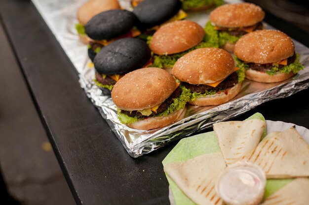 juicy burgers and black burgers on a food court counter street food