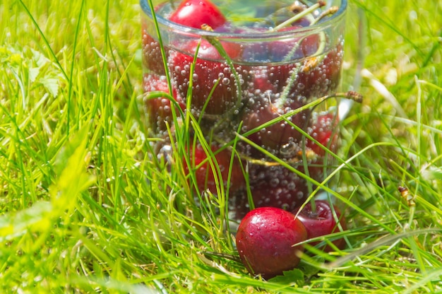 Juicy cherry in water on the grass on a Sunny day.