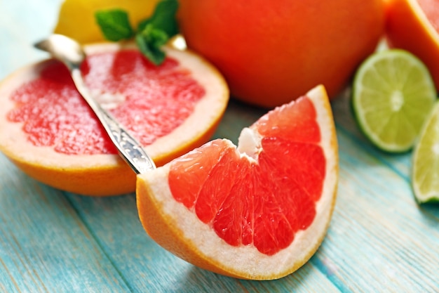 Photo juicy composition of citrus fruits on wooden surface, close up