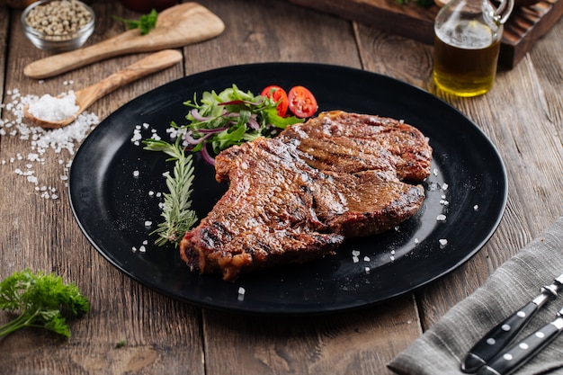 Juicy cowboy steak on a black plate