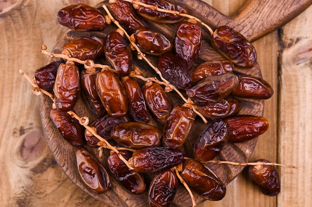 Juicy dates on a wooden table. Dried fruits for a healthy diet. Copy space