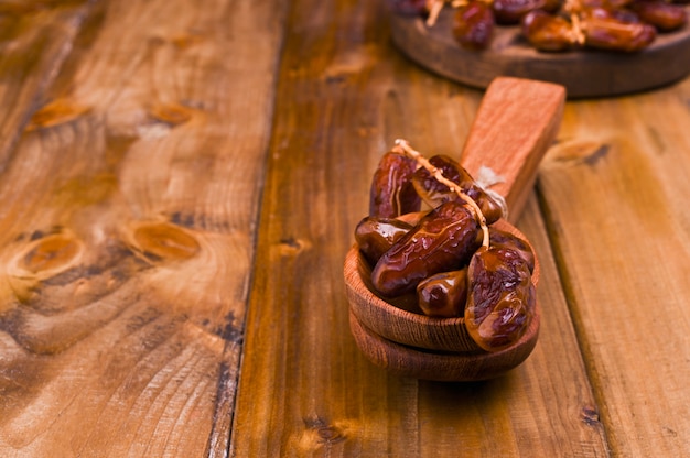 Juicy dates on a wooden table. Dried fruits for a healthy diet. Copy space